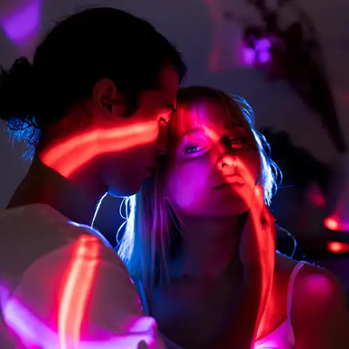 Couple embracing under neon lights, lost in the moment