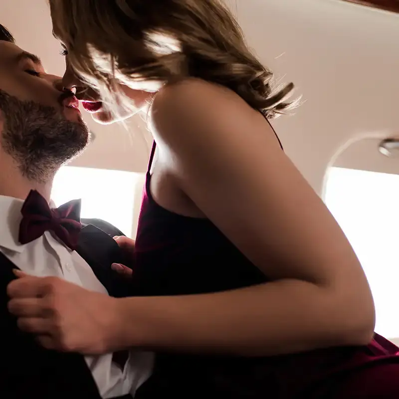 Couple kissing passionately in private jet seat